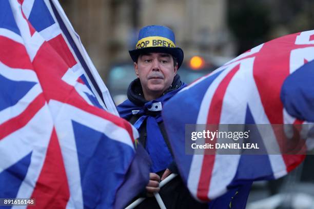 Pro-EU, anti-Brexit demonstrator Steve Bray waves EU and Union Flags outside the Houses of Parliament in central London on December 13, 2017 as MPs...