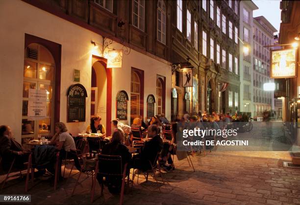 Group of people sitting at a sidewalk cafe, Bermuda Triangle, Vienna, Austria