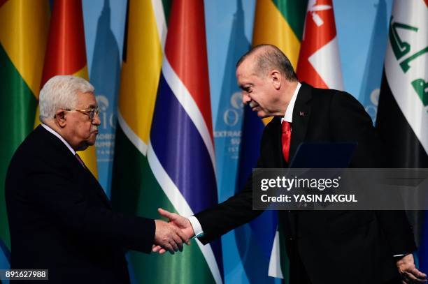 Turkish President Recep Tayyip Erdogan shakes hands with Palestinian President Mahmoud Abbas after a press conference following the Extraordinary...