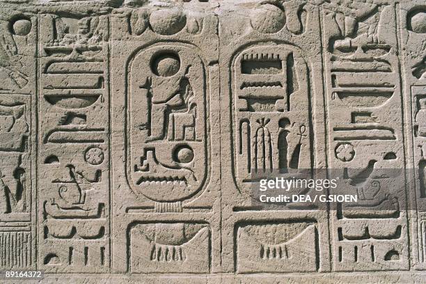 Cartouches at base of colossal sandstone figures of enthroned Ramses II