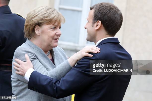 German chancellor Angela Merkel is welcomed by French President Emmanuel Macron upon at his arrival for a summit from the underfunded G5 Sahel...