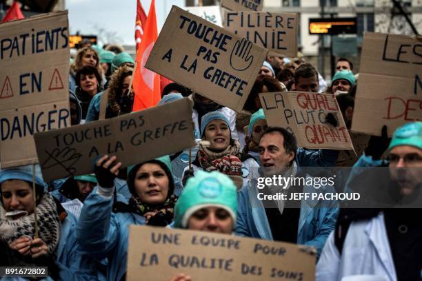 Woman holds a placard reading "Don't touch the transplants" as employees of the Lyon Croix Rousse hospital demonstrate on December 13, 2017 in Lyon,...