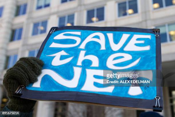 Woman holds a 'Save the Net' protest sign during a demonstration against the proposed repeal of net neutrality outside the Federal Communications...