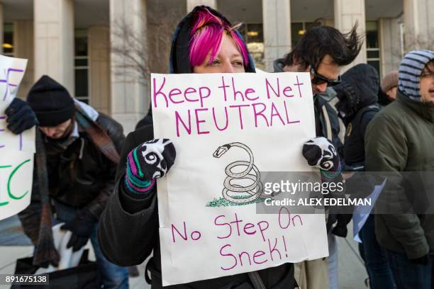 Woman holds a 'Keep the Net Neutral, No Step On Snek' protest sign during a demonstration against the proposed repeal of net neutrality outside the...