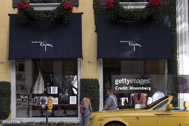 Pedestrians view holiday window displays at the House of Bijan store on Rodeo Drive in Beverly Hills, California, U.S., on Saturday, Dec. 9, 2017....