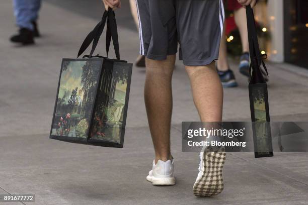Shopper carries Gucci Group NV bags on Rodeo Drive in Beverly Hills, California, U.S., on Saturday, Dec. 9, 2017. The U.S. Census Bureau is scheduled...