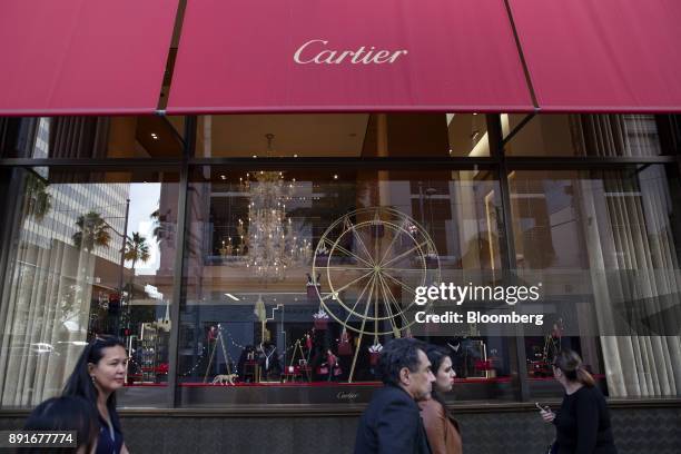 Pedestrians pass in front of a holiday window display at the Cartier Ltd. Jewelry store on Rodeo Drive in Beverly Hills, California, U.S., on...