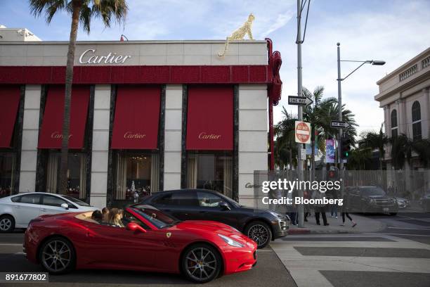 Ferrari NV vehicle passes in front of the Cartier Ltd. Jewelry store on Rodeo Drive in Beverly Hills, California, U.S., on Saturday, Dec. 9, 2017....