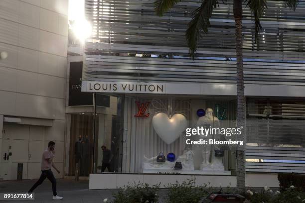 Pedestrian passes in front a holiday window display at the LVMH Moet Hennessy Louis Vuitton SE store on Rodeo Drive in Beverly Hills, California,...