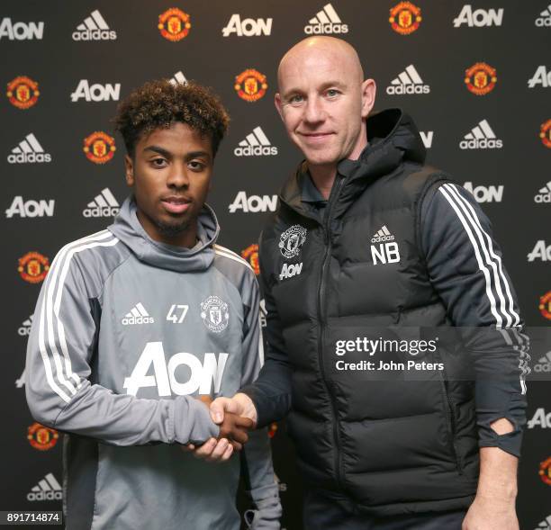 Angel Gomes of Manchester United poses with Nicky Butt after signing his first professional contract with the club at Aon Training Complex on...