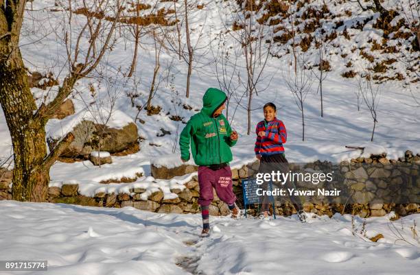 Kashmiri children play on snow after the seasons first snowfall on December 13, 2017 In the outskirts of Srinagar, the summer capital of Indian...