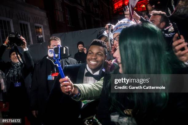 John Boyega takes a selfie with a fan at the European Premiere of Star Wars: The Last Jedi at the Royal Albert Hall on December 12, 2017 in London,...