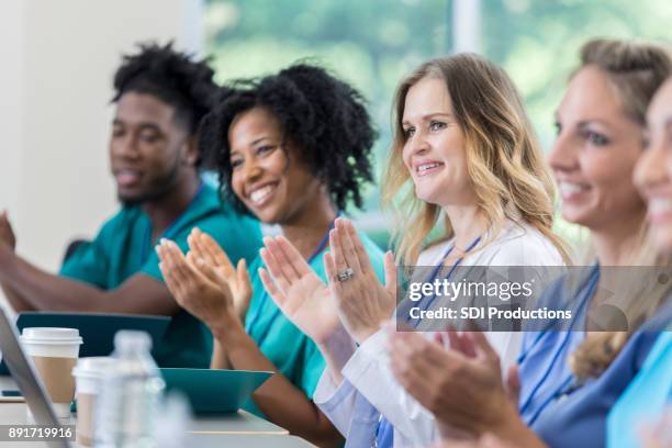 healthcare professionals clap after lecture - applauding nurses stock pictures, royalty-free photos & images