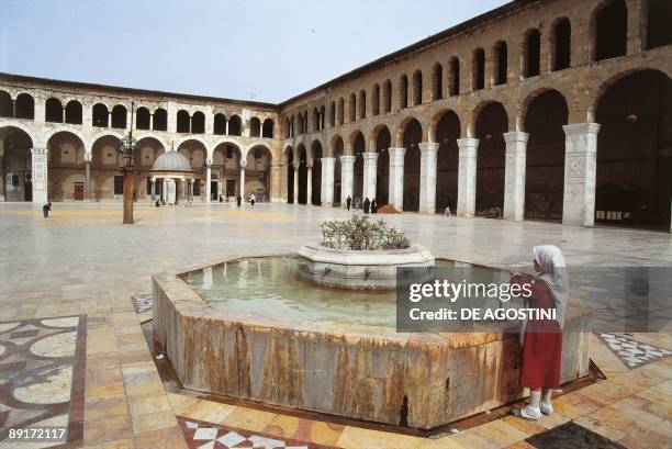Rear view of a woman standing near a fountain in a mosque, Umayyad Mosque, Damascus, Syria