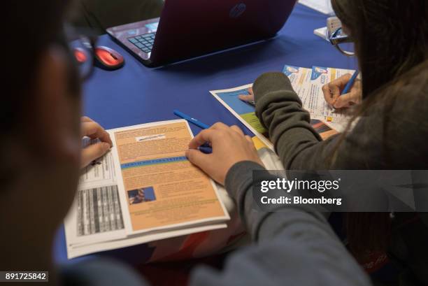 Puerto Ricans fill out paperwork at the Osceola County Hurricane Maria Reception Center in Kissimmee, Florida, U.S., on Tuesday, Dec. 12, 2017. After...