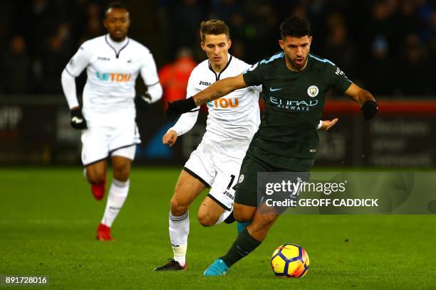 Swansea City's English midfielder Tom Carroll vies with Manchester City's Argentinian striker Sergio Aguero during the English Premier League...