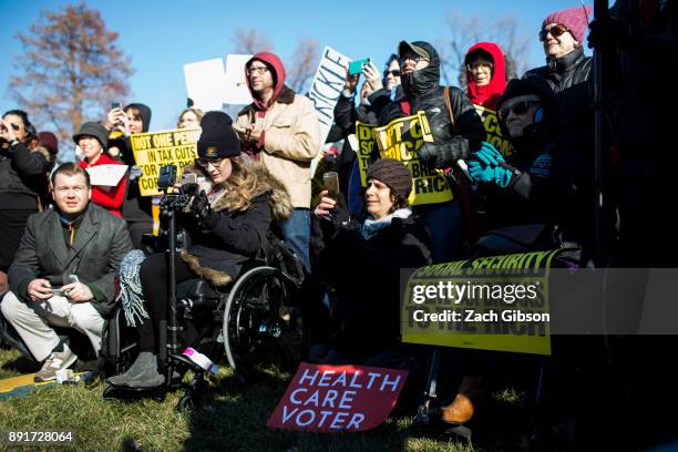 Demonstrators listen to speakers during a rally against the Republican tax plan on December 13, 2017 in Washington, DC.