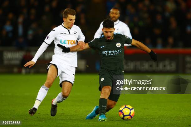 Swansea City's English midfielder Tom Carroll vies with Manchester City's Argentinian striker Sergio Aguero during the English Premier League...