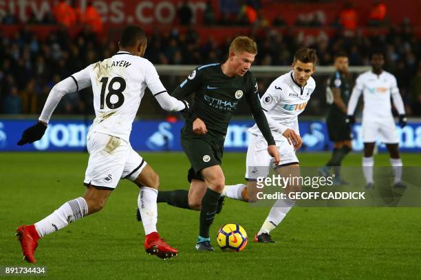 Manchester City's Belgian midfielder Kevin De Bruyne vies with Swansea City's Ghanaian striker Jordan Ayew and Swansea City's English midfielder Tom...