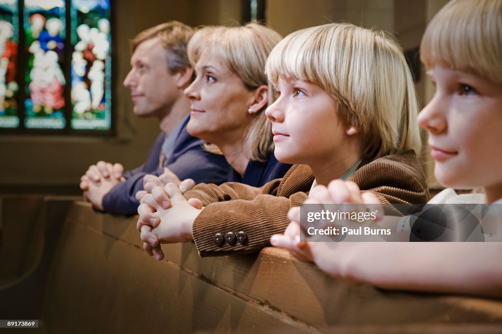 Family Kneeling and Praying in Church