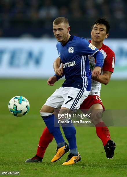 Max Meyer of Schalke and Koo Ja Cheol of Augsburg battle for the ball during the Bundesliga match between FC Schalke 04 and FC Augsburg at...