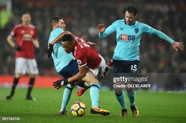 Manchester United's French striker Anthony Martial is tackled by Bournemouth's Australian midfielder Brad Smith during the English Premier League...