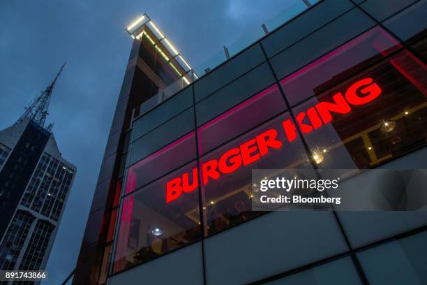 Signage is seen illuminated at night in the window of a Burger King do Brasil restaurant on Paulista Avenue in Sao Paulo, Brazil, on Monday, Dec. 11,...