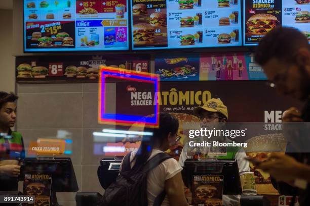 An employee assists a customer at a Burger King do Brasil restaurant in Sao Paulo, Brazil, on Monday, Dec. 11, 2017. Burger King do Brasil may raise...