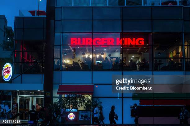 Signage is seen illuminated at night in the window of a Burger King do Brasil restaurant on Paulista Avenue in Sao Paulo, Brazil, on Monday, Dec. 11,...