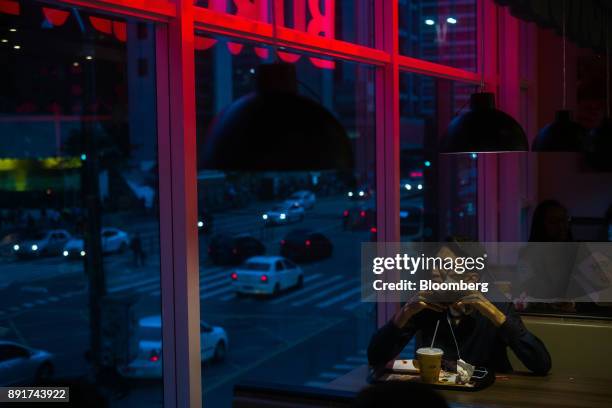 Customer sits inside a Burger King do Brasil restaurant on Paulista Avenue in Sao Paulo, Brazil, on Monday, Dec. 11, 2017. Burger King do Brasil may...