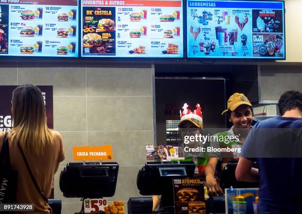 Employees assist customers at a Burger King do Brasil restaurant in Sao Paulo, Brazil, on Monday, Dec. 11, 2017. Burger King do Brasil may raise as...