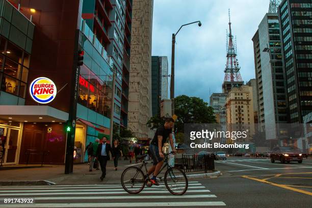 Cyclist rides in front of a Burger King do Brasil restaurant on Paulista Avenue in Sao Paulo, Brazil, on Monday, Dec. 11, 2017. Burger King do Brasil...