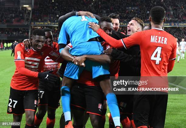 Rennes' French goalkeeper Abdoulaye Diallo is congratulated by his teammates after winning the French League Cup round of 16 football match between...