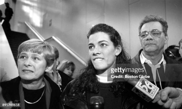 Figure skater Nancy Kerrigan, flanked by her mother Brenda, left, and her father Daniel, talks to reporters upon her arrival at Logan Airport in...