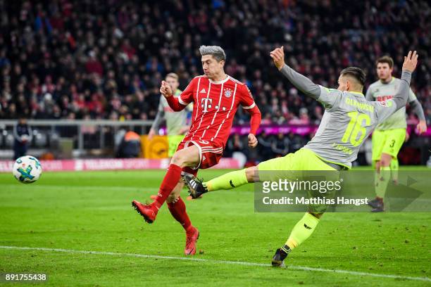 Robert Lewandowski of Bayern Munich scores his team's first goal past Pawel Olkowski of 1.FC Koeln to make it 1-0 during the Bundesliga match between...