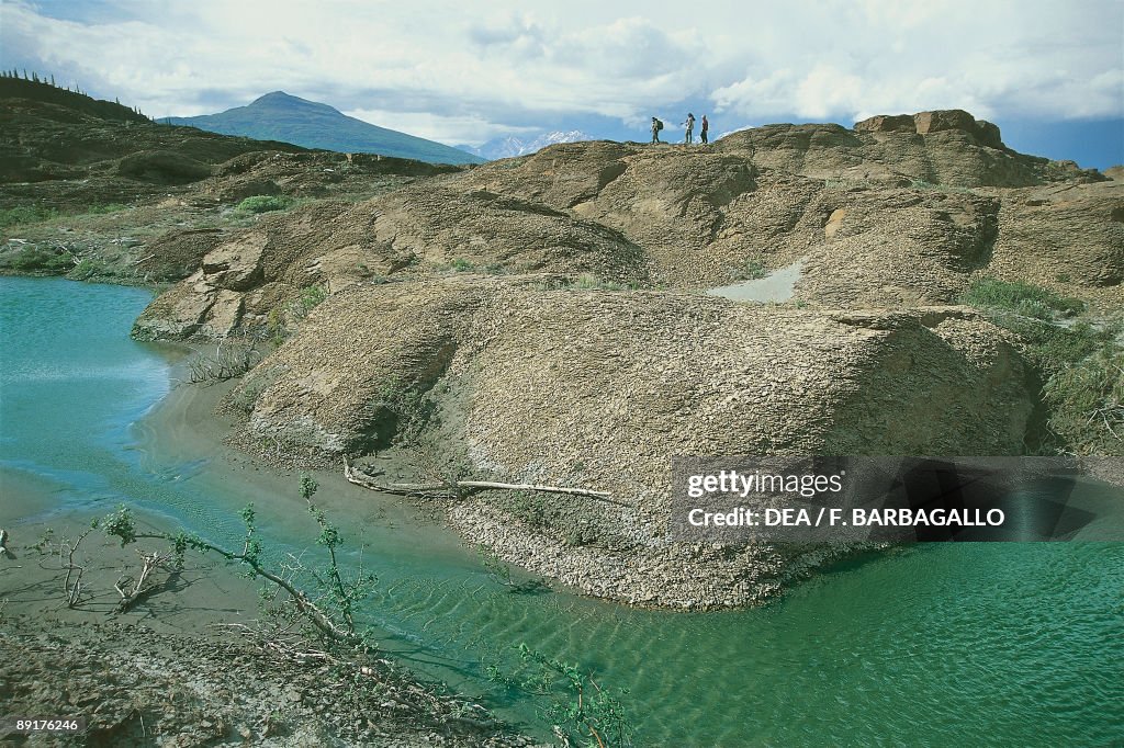 Three people on rocks, Alsek River, Yukon, Canada