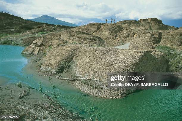 Three people on rocks, Alsek River, Yukon, Canada