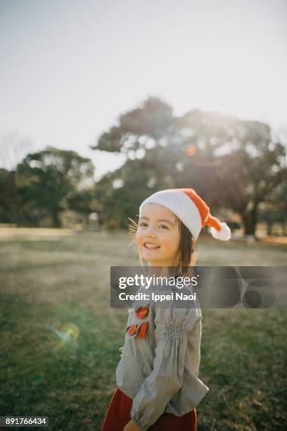 Cheerful mixed race little girl wearing santa claus hat