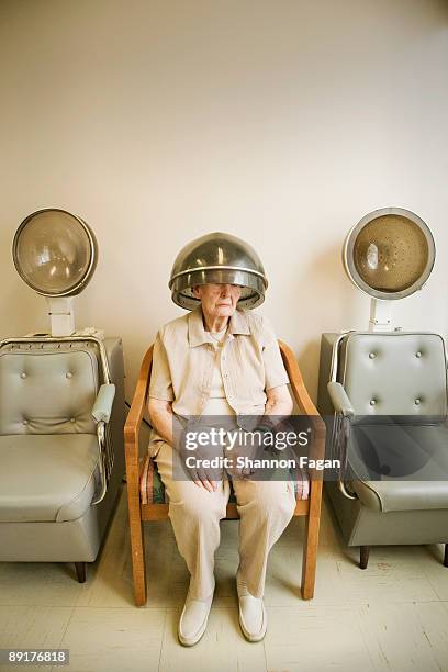 elderly woman at salon with rollers in hair - at hairdresser stock-fotos und bilder