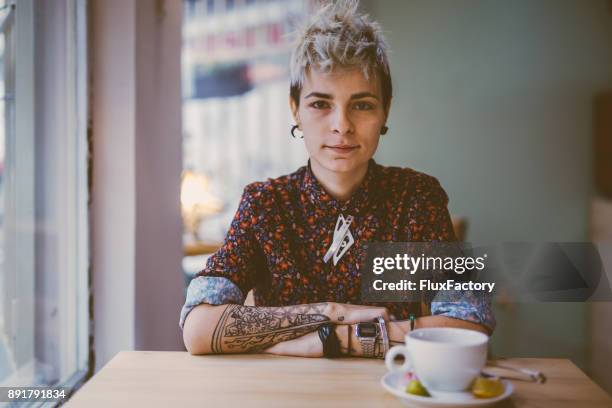 tattooed woman in a cafe - punk person stock pictures, royalty-free photos & images