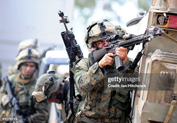 Marine from the 31st Marine Expenditionary Unit fires his rifle from behind an amoured personal carrier during the combined urban combat training...