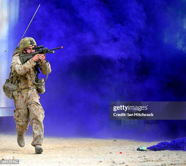 An Australian soldier who is role playing as an enemy soldier fires his rifle as he runs for cover as U.S Marines from the 31st Marine Expeditionary...