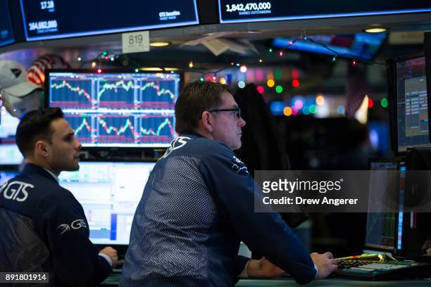 Traders and financial professionals work on the floor of the New York Stock Exchange ahead of the closing bell, December 13, 2017 in New York City....