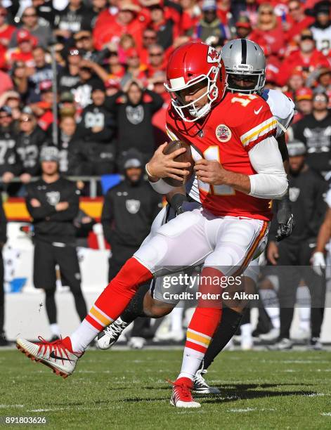 Quarterback Alex Smith of the Kansas City Chiefs gets tackled by outside linebacker Bruce Irvin of the Oakland Raiders during the first half at...