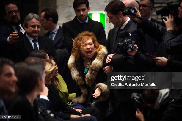 Woman protests during the book launch of Bruno Vespa, 'Soli al Comando', on December 13, 2017 in Rome, Italy.