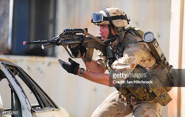 An Australian soldier who is role playing as an enemy soldier fires his rifle as U.S Marines from the 31st Marine Expeditionary Unit attack during...
