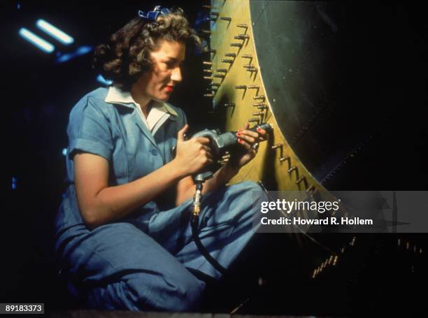 Portrait of an unidentified female riveter at work on bomber at Consolidated Aircraft Corporation, Fort Worth, Texas, October 1942.