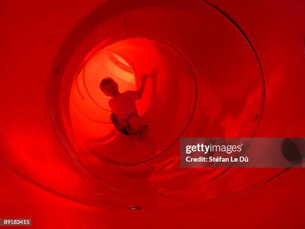 little boy in red playground slide - inner tube stock-fotos und bilder