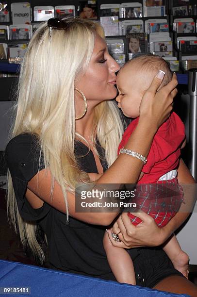 Brooke Hogan poses with a baby during her new CD release at FYE at Dolphin Mall on July 21, 2009 in Miami, Florida.
