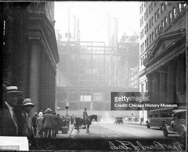 View of the steel frame of the new Board of Trade building during construction, looking south on LaSalle Street, located at the head of LaSalle...